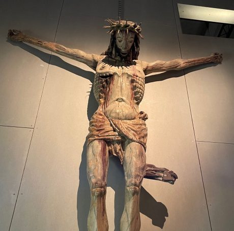 Träskulptur som föreställer den korsfäste Jesus. Han hänger med huvudet och det rinner blod.