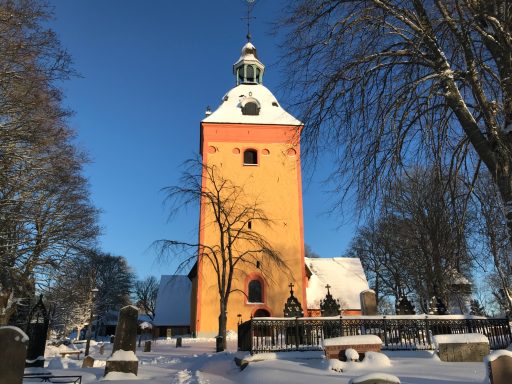 Ösmo kyrka i strålande sol en vinterdag med mycket snö.